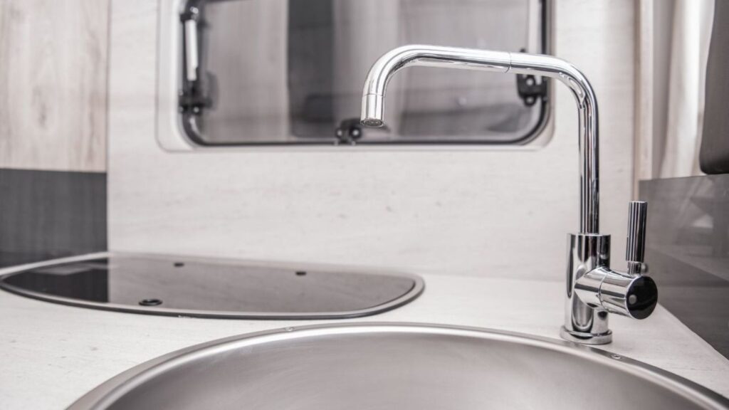 RV toilet and sink setup being inspected by a technician using handheld diagnostic tools